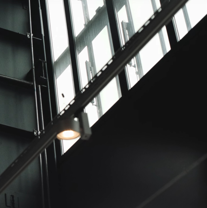 A photo of an industrial hall with metal beams and large windows